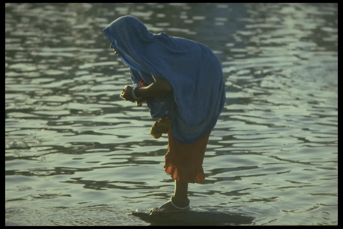 Woman blue veil river bathing