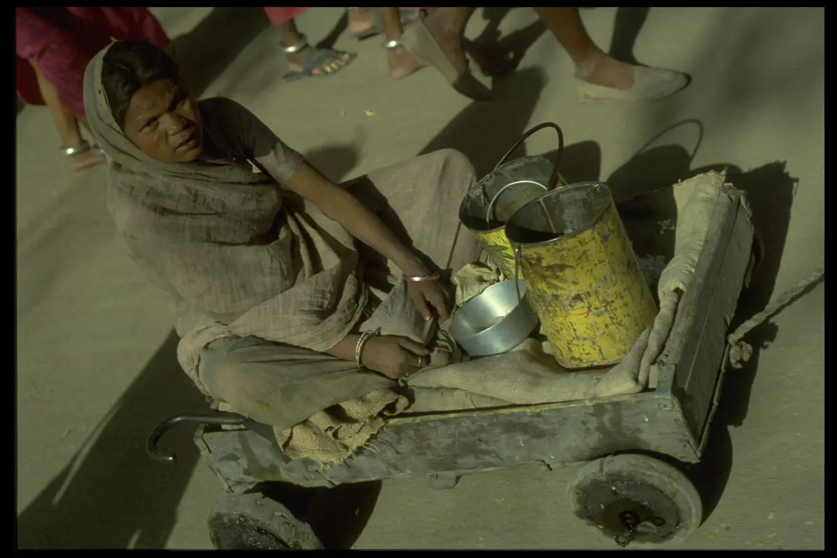 Woman seated handcart tin cans